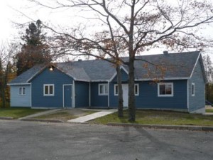 Le local du 112e, bâtiment bleu entouré d'arbres